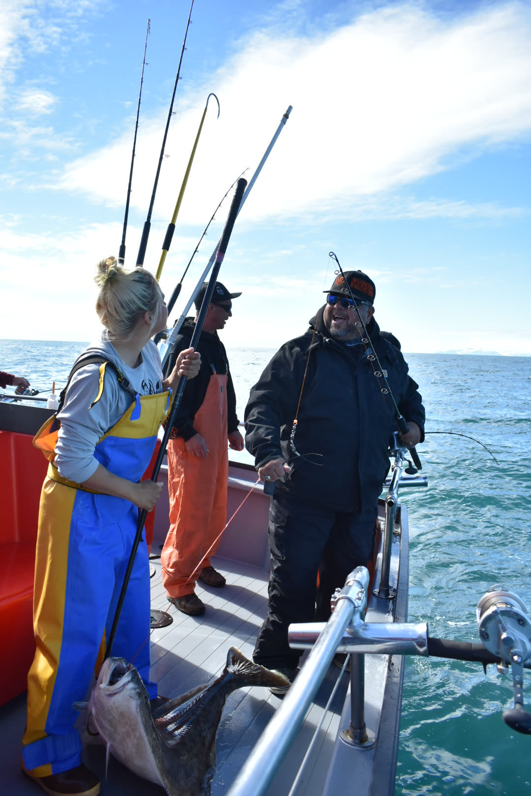 Mack Attack and his crew stand on an Alaska fishing boat beside a freshly landed 40-pound halibut.
