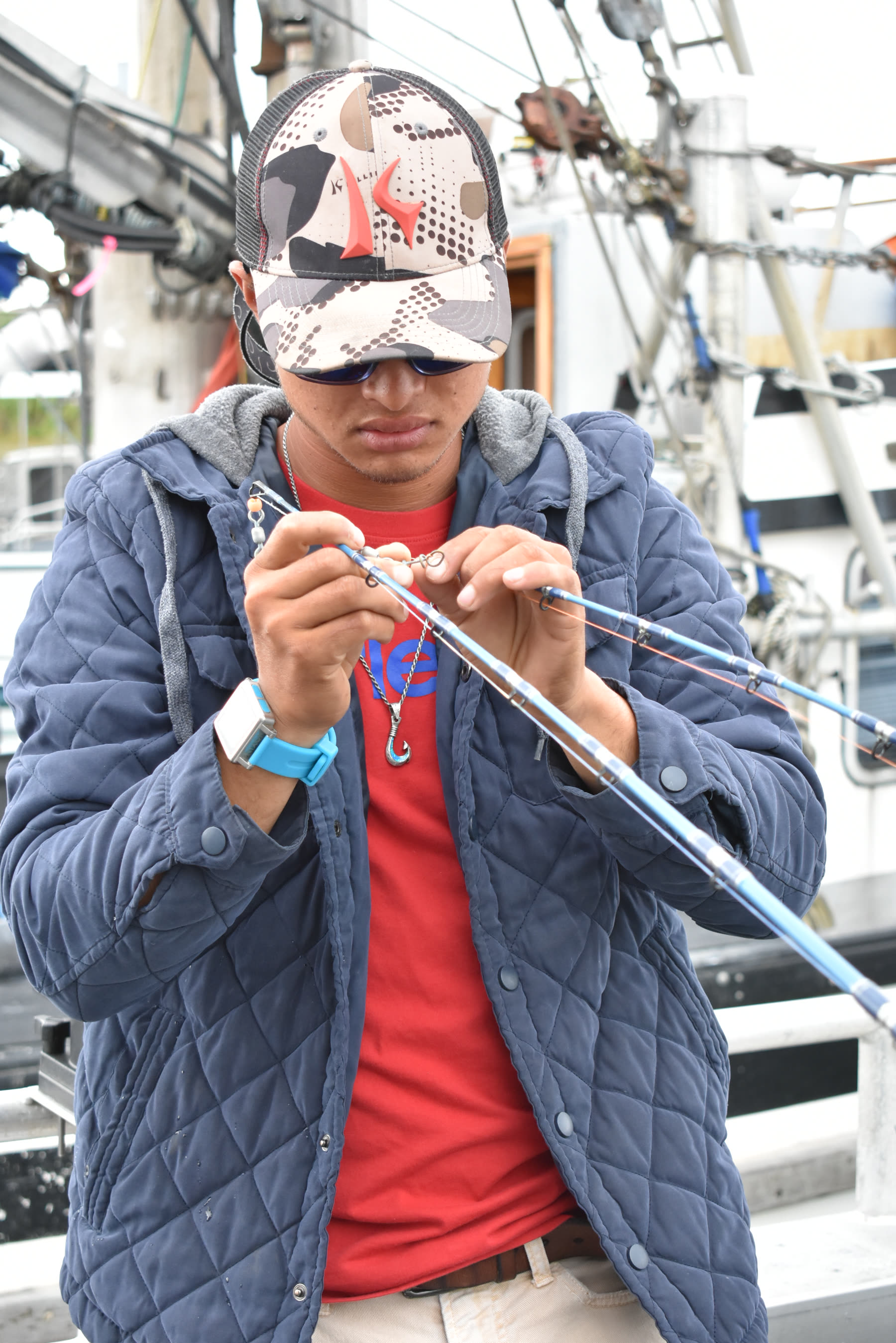 Captain Pono prepares fishing tackle aboard an Alaska charter boat before heading out.